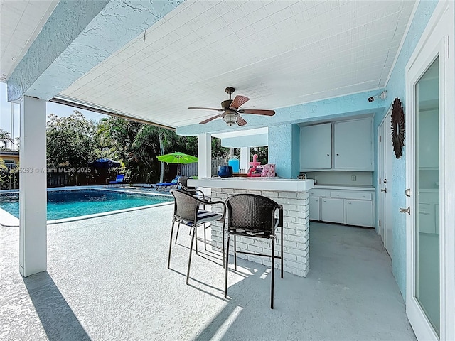 view of patio featuring fence and ceiling fan
