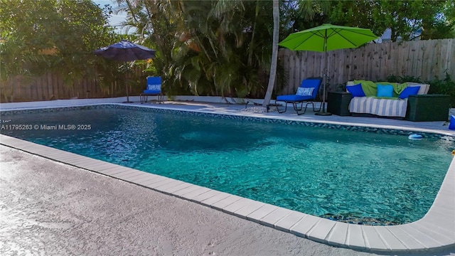 view of swimming pool with a fenced backyard and a patio