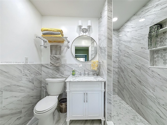 full bathroom with tile walls, walk in shower, toilet, vanity, and marble finish floors