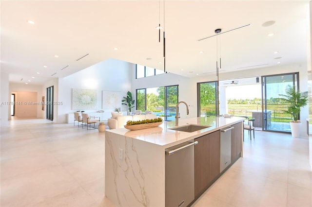 12060 NW 67th Ct, Parkland, FL 33076 - kitchen with stainless steel dishwasher, modern cabinets, a sink, open floor plan, and a kitchen island with sink