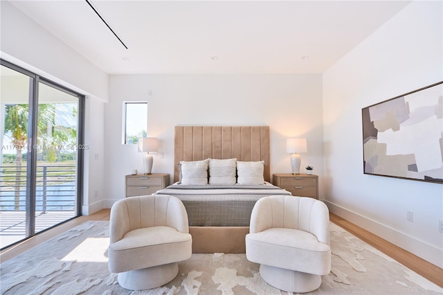 12060 NW 67th Ct, Parkland, FL 33076 - bedroom featuring access to exterior, light wood-style floors, and baseboards