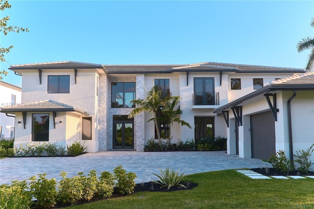 12060 NW 67th Ct, Parkland, FL 33076 - prairie-style home featuring stucco siding, decorative driveway, a tiled roof, french doors, and a front yard