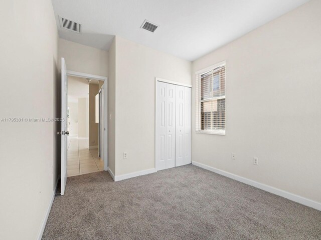 1416 SE 26th Ave, Homestead, FL 33035 - unfurnished bedroom featuring a closet, baseboards, carpet flooring, and visible vents