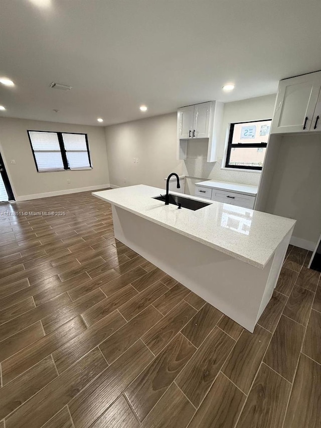 1770 NW 109th St, Miami, FL 33167 - kitchen featuring white cabinetry, light stone counters, a sink, and wood tiled floor