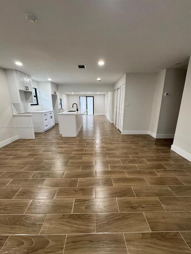 1770 NW 109th St, Miami, FL 33167 - interior space featuring baseboards, a kitchen island with sink, wood finish floors, and recessed lighting