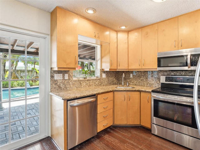 4400 NE 13th Ave, Oakland Park, FL 33334 - kitchen featuring a sink, dark wood finished floors, light brown cabinetry, decorative backsplash, and appliances with stainless steel finishes