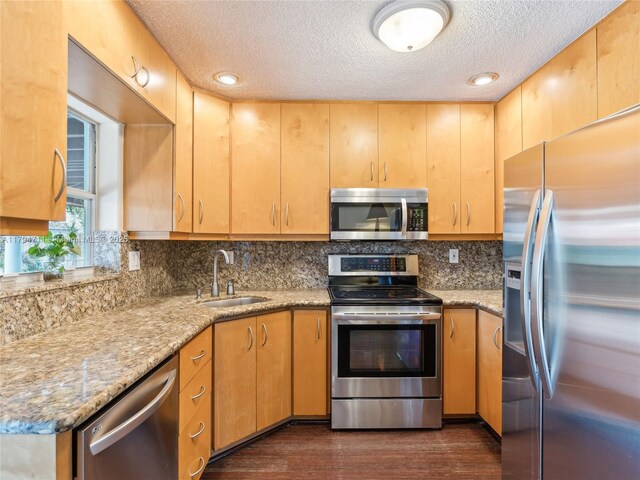 4400 NE 13th Ave, Oakland Park, FL 33334 - kitchen featuring a sink, dark wood finished floors, a textured ceiling, backsplash, and appliances with stainless steel finishes