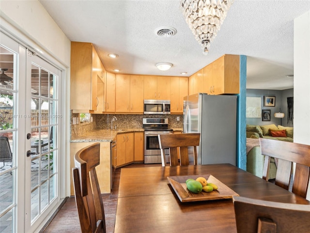4400 NE 13th Ave, Oakland Park, FL 33334 - kitchen featuring stainless steel appliances, tasteful backsplash, a healthy amount of sunlight, and light brown cabinetry