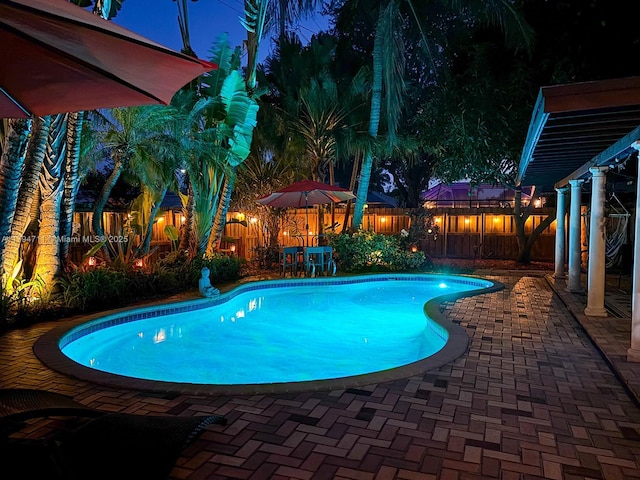 4400 NE 13th Ave, Oakland Park, FL 33334 - pool at night featuring a fenced in pool, a patio, and a fenced backyard