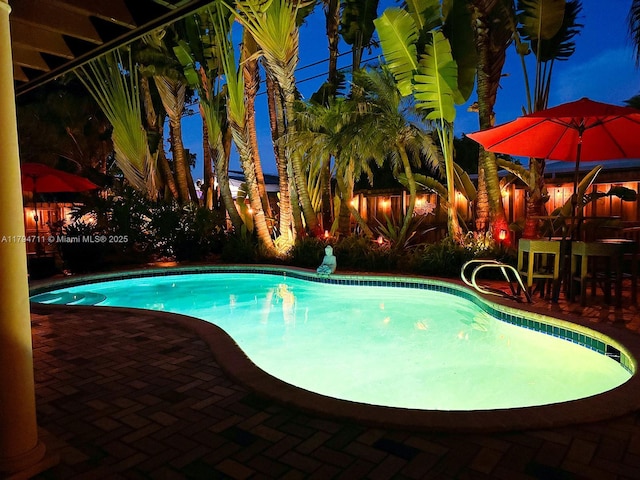 4400 NE 13th Ave, Oakland Park, FL 33334 - pool at twilight with a fenced in pool, a fenced backyard, and a patio area