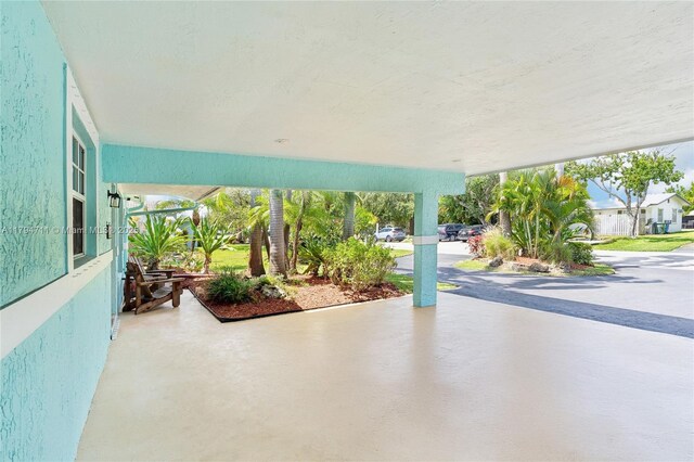 4400 NE 13th Ave, Oakland Park, FL 33334 - view of front facade with aphalt driveway, fence, and a carport