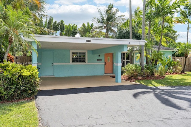 4400 NE 13th Ave, Oakland Park, FL 33334 - view of front of house with aphalt driveway, fence, and an attached carport