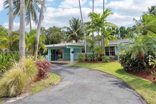4400 NE 13th Ave, Oakland Park, FL 33334 - view of front of home featuring an attached carport, a standing seam roof, a front lawn, and aphalt driveway