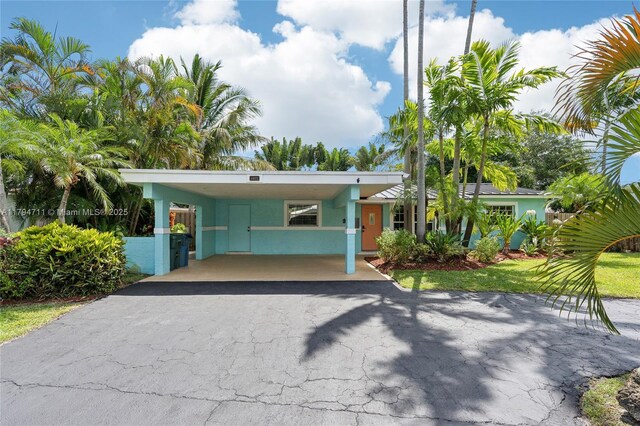 4400 NE 13th Ave, Oakland Park, FL 33334 - view of front of property featuring stucco siding, driveway, and an attached carport