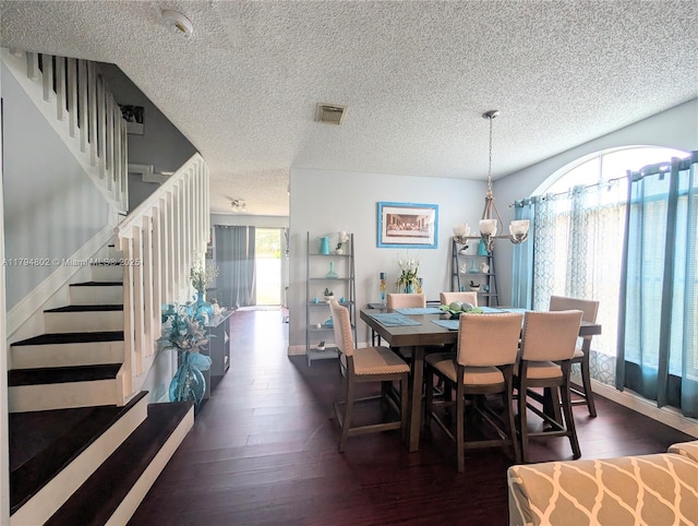 dining area with wood-type flooring, stairs, and a textured ceiling