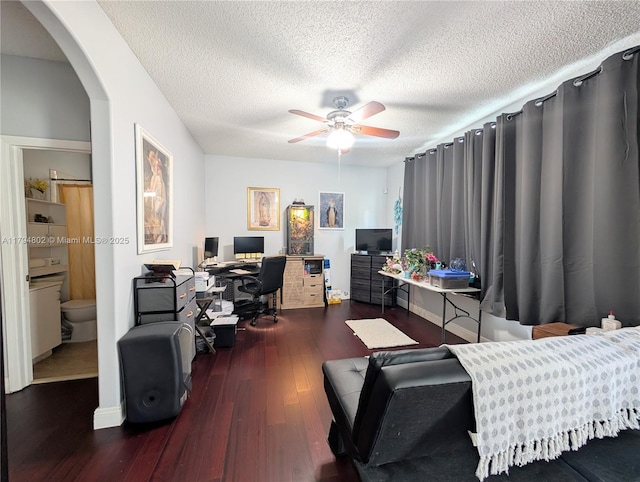 interior space featuring arched walkways, a textured ceiling, ceiling fan, and wood finished floors