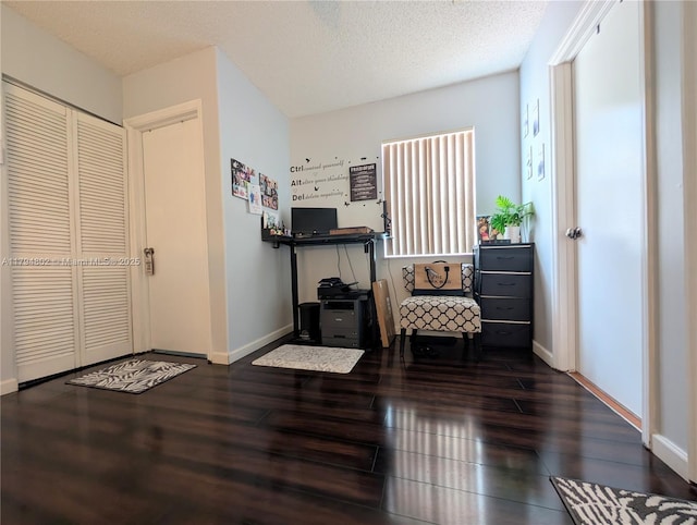 sitting room featuring baseboards, a textured ceiling, and wood finished floors