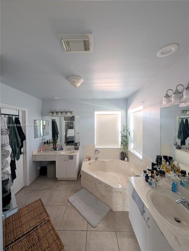 full bathroom featuring a bath, visible vents, a sink, and tile patterned flooring