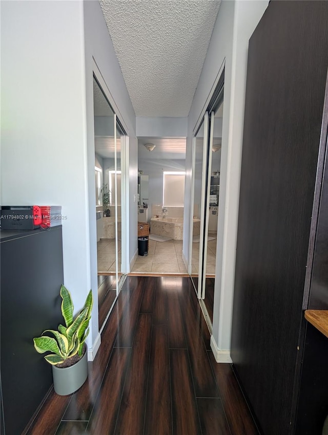 hall featuring a textured ceiling and wood finished floors