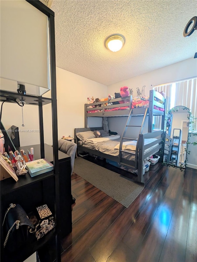 bedroom with a textured ceiling and wood finished floors
