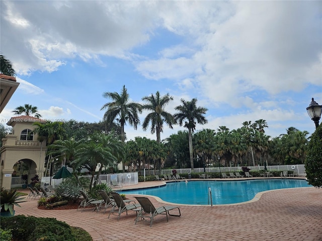 community pool featuring fence and a patio area