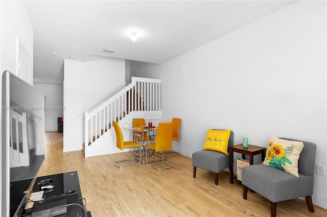 sitting room featuring baseboards, stairs, wood finished floors, and visible vents