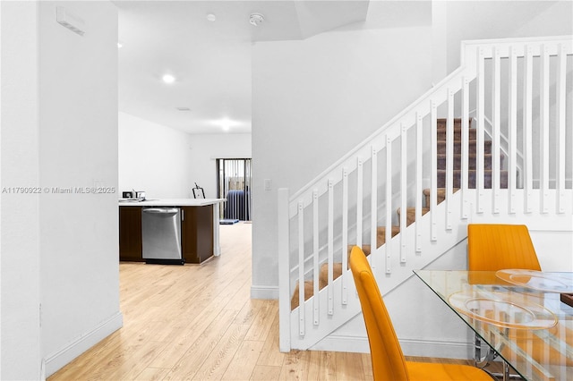 staircase with baseboards and wood finished floors