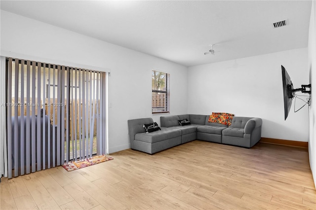 living room featuring visible vents, baseboards, and wood finished floors