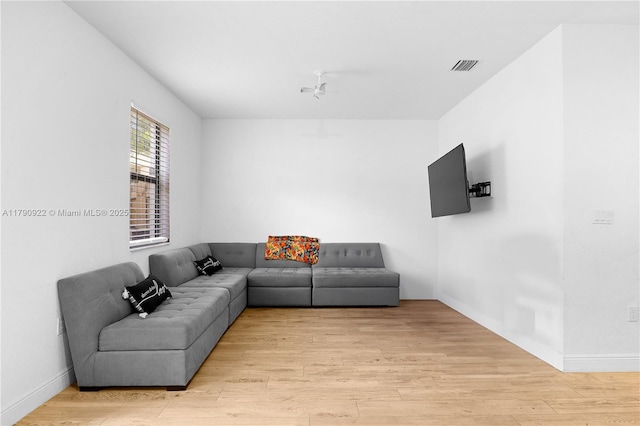 living room with baseboards, light wood-style flooring, and visible vents