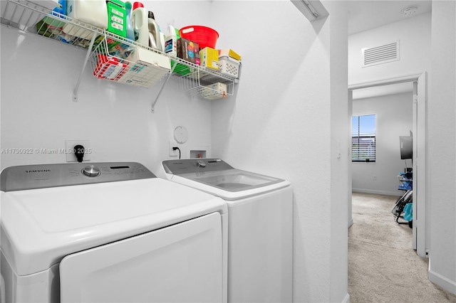 washroom with laundry area, visible vents, baseboards, light carpet, and washer and clothes dryer