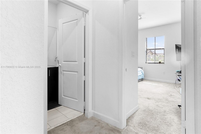 corridor with carpet floors and baseboards