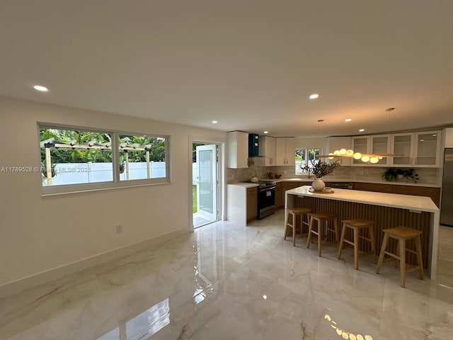 360 NE 118th St, Miami, FL 33161 - kitchen with decorative backsplash, a kitchen island, baseboards, a kitchen bar, and recessed lighting