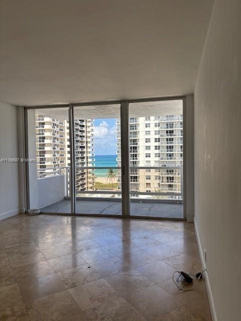 empty room with baseboards and floor to ceiling windows