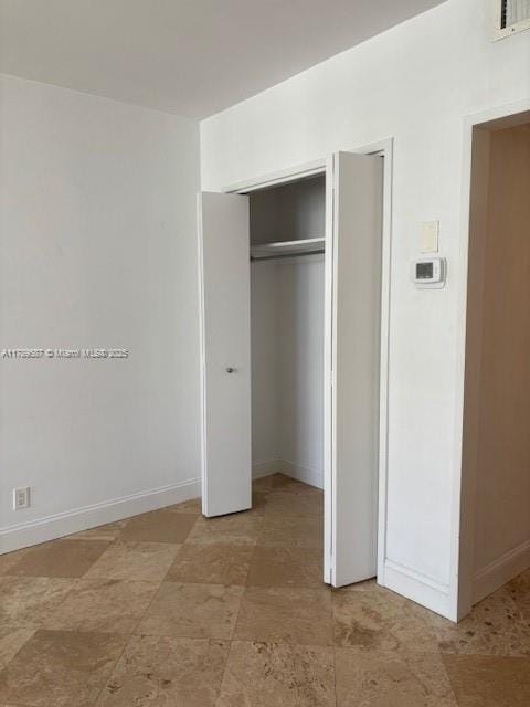 unfurnished bedroom with baseboards, visible vents, and a closet