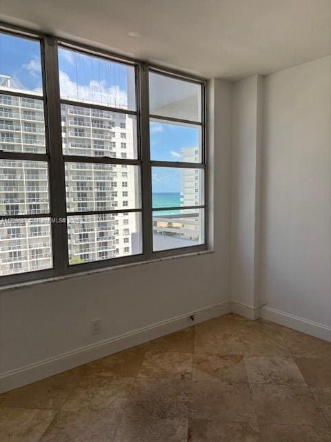 unfurnished room with baseboards