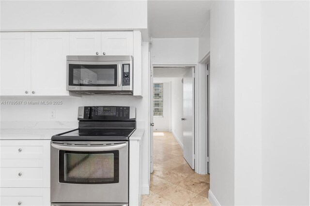 5700 Collins Ave Unit 10D, Miami Beach, FL 33140 - kitchen featuring appliances with stainless steel finishes, white cabinetry, and light countertops
