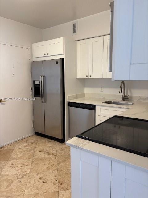 kitchen with white cabinetry, appliances with stainless steel finishes, a sink, and visible vents
