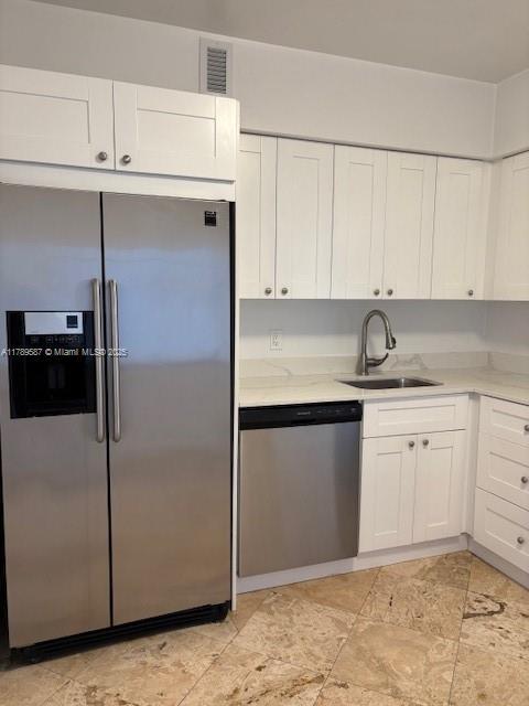 kitchen with white cabinets, a sink, light countertops, stainless steel appliances, and visible vents