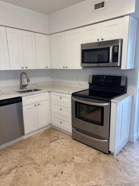 kitchen featuring visible vents, a sink, white cabinetry, and appliances with stainless steel finishes