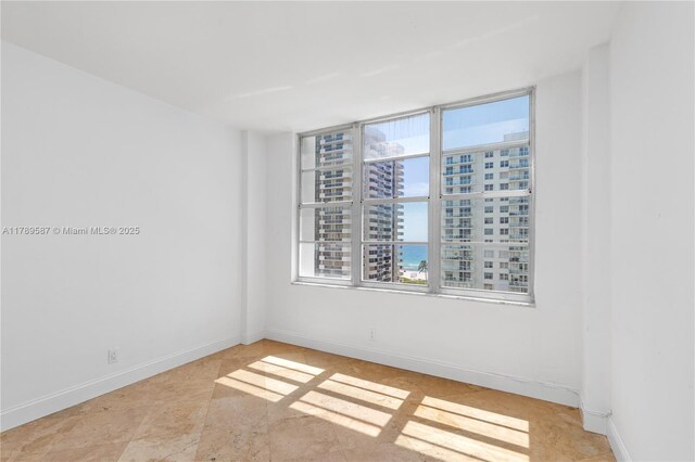 5700 Collins Ave Unit 10D, Miami Beach, FL 33140 - empty room featuring a city view and baseboards