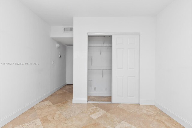 5700 Collins Ave Unit 10D, Miami Beach, FL 33140 - unfurnished bedroom with a closet and stone finish floors