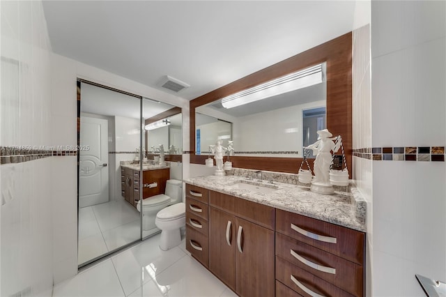 bathroom with tile patterned floors, vanity, toilet, and visible vents