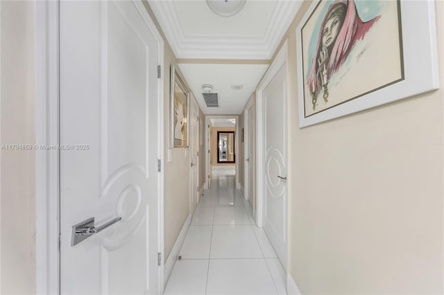 corridor featuring baseboards, crown molding, and light tile patterned flooring