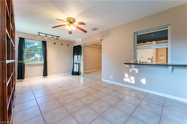spare room featuring visible vents, rail lighting, ceiling fan, and light tile patterned flooring