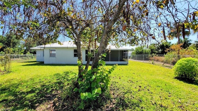view of yard with a sunroom and a fenced backyard