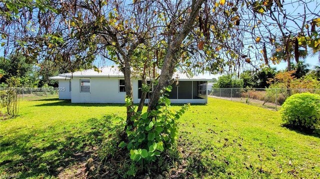 3054 NE Beechwood Cir, La Belle, FL 33935 - view of yard with a sunroom and a fenced backyard