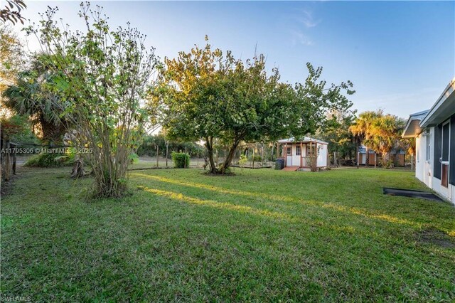 3054 NE Beechwood Cir, La Belle, FL 33935 - view of yard featuring fence, an outbuilding, and a shed