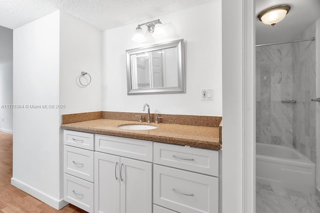 bathroom featuring a textured ceiling, shower / bathing tub combination, and vanity