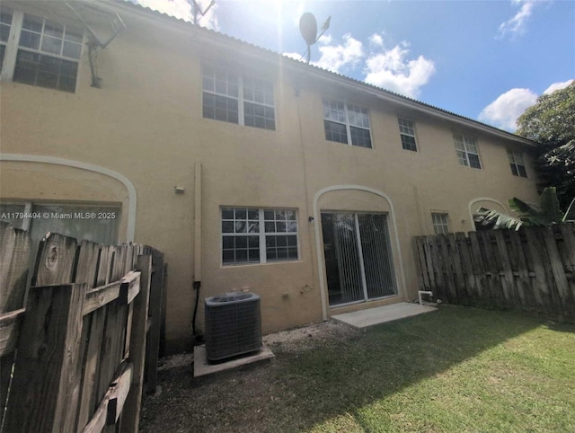 back of house featuring fence, a yard, stucco siding, and cooling unit