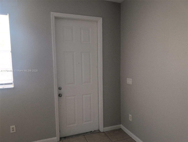 interior space featuring baseboards and light tile patterned floors